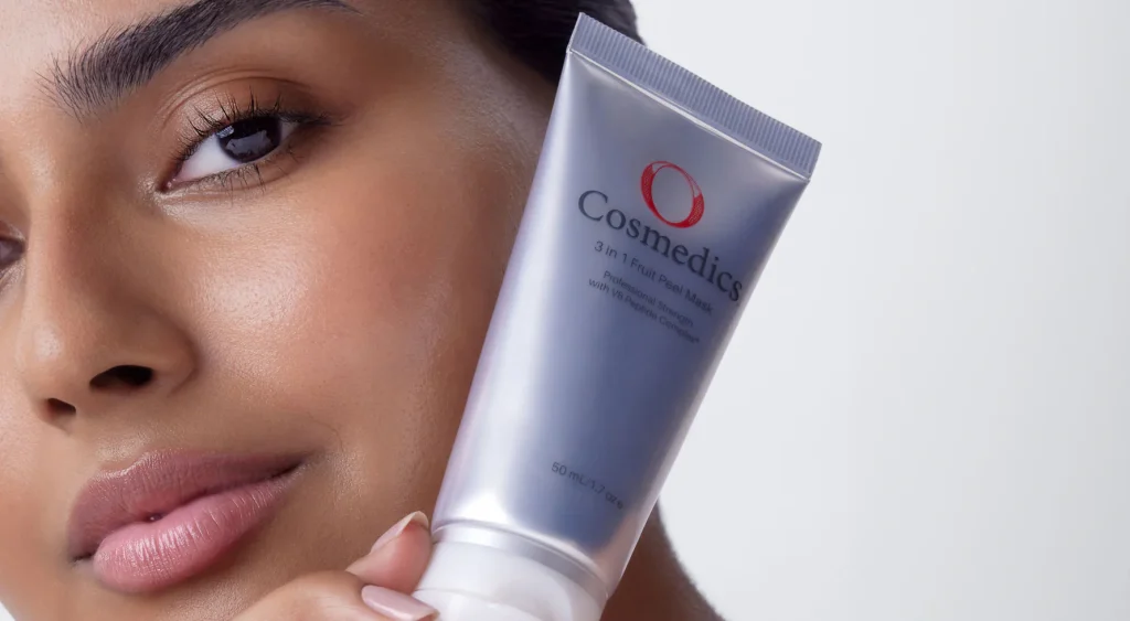 blog-guide-the-low-down-on-exfoliation-hero A model holding a tube of 3-in-1 Fruit Peel Mask onto her faec