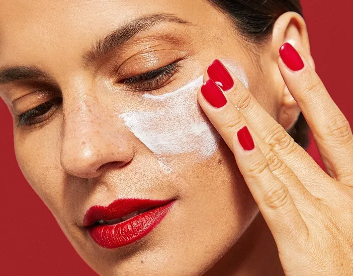 Woman applying Mineral Pro Sunscreen on her face